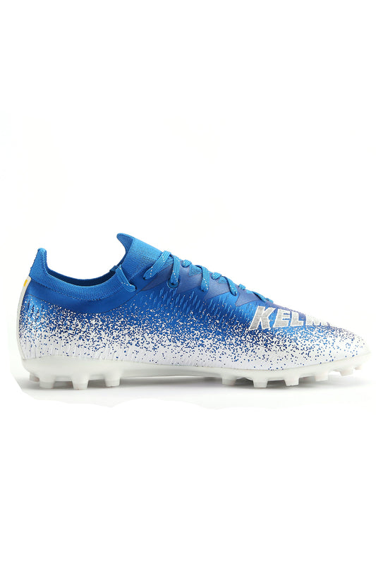 A pair of blue Kelme Raider Football Boots with a geometric pattern and white accents, featuring a seamless design and studless sole for artificial grass.